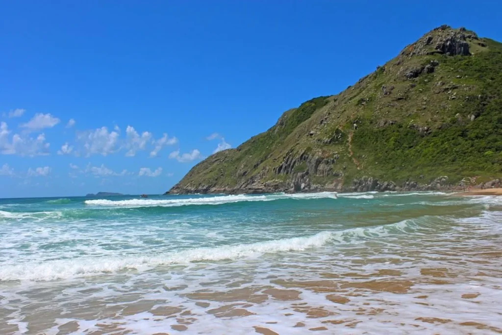 Mar azul e montanhas verdes vistos da praia Lagoinha do Leste após a trilha em Florianópolis