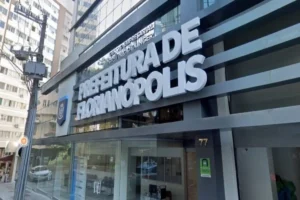 Fachada moderna da Prefeitura de Florianópolis, com letreiro em destaque e entrada de vidro localizada no centro da cidade.